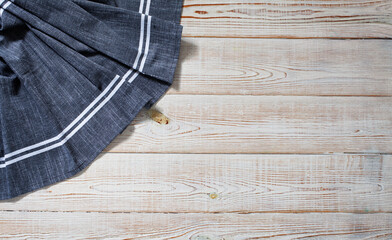 Blue tablecloth, napkin, rough fabric texture with creased folds on wooden desk top view.