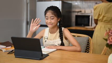 Happy asian child learning online at virtual class on laptop computer. Concept of Virtual education, homeschooling