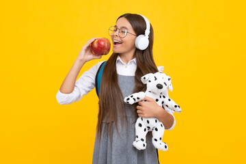 Back to school. Teenager schoolgirl hold toy. School children with favorite toys on isolated yellow studio background.