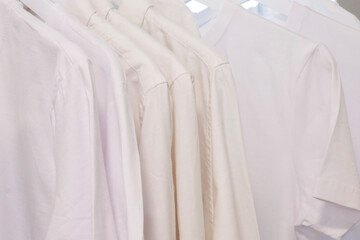 White clothes closeup hanging on white hangers.