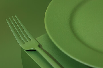Green plate with colored cutlery on the green background.