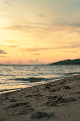 Sandy beach, surf and coastline at colorful sunset