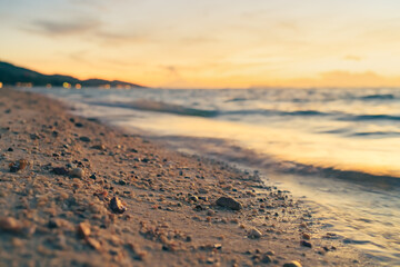 Sandy beach, surf and coastline at colorful sunset