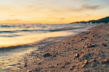 Sandy beach, surf and coastline at colorful sunset