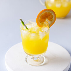 Glasses of Fresh Orange Juice on White Wooden Tray Blue Background Square