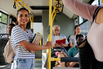 Young smiling student in crowded bus - obrazy, fototapety, plakaty