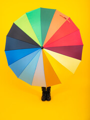 Autumn kids concept. Child teenager girl covered under rainbow umbrella in autumn black leather...