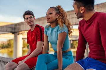 Young multi - ethnic friends talking after exercise