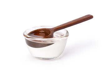 Cold pressed extra virgin coconut oil in glass bowl with wooden spoon isolated on white background....