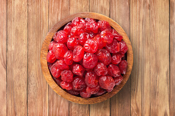 candied fruit, dried cherry with sugar in bowl on wooden table background, top view. organic...