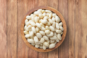 peanut peeled in bowl on wooden table background, top view. organic vegetarian food.