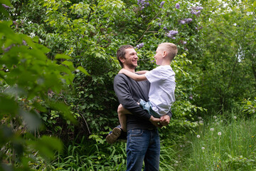 Dad holds his son in his arms and they laugh