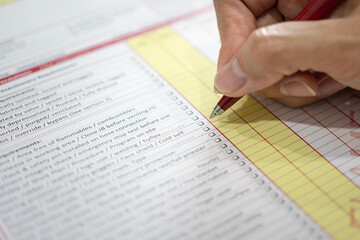 Action of safety officer is using a pen to marking checklist in work permit document form. Safety...
