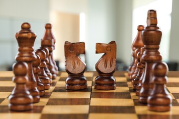 Vintage chess pieces on a chessboard on a table indoors.