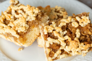 Square slice apple pie with walnuts on white porcelain plate in selective focus. Breakfast or after-dinner dessert concept.