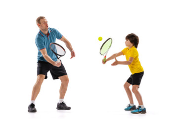 Training. Professional tennis player, coach teaches teen to play tennis isolated over white studio...