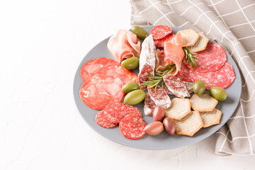 Charcuterie plate with different types of sausages - salami, bresaola, proscuitto served with...
