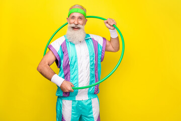 Photo of cheerful healthy granddad hold hula hoop wear condensed milk color sport suit isolated on...