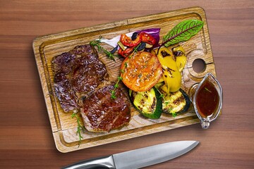 Fototapeta na wymiar Tasty meat dish served on wooden board