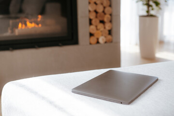 interior of a modern country house with a fireplace and a laptop on the sofa