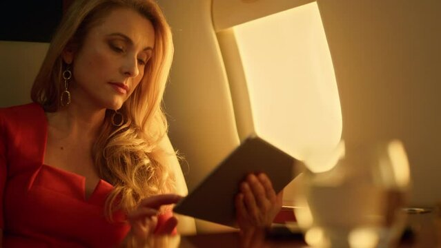 Focused ceo working tablet computer on airplane closeup. Boss talk virtual meet