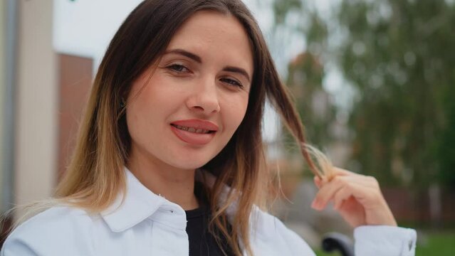Portrait smiling simon young woman in formal outfit on street and feeling happy. Modern urban town landscape, female wearing spring clothes