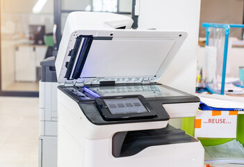 Close up copier machine and resuse paper station in modern office.