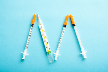 Medical syringes on blue background. Simple medicine concept flat lay.