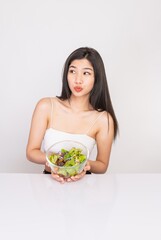 Portrait photo of a young beautiful asian female lady with a bowl of mixed salad in her hand. Good for healthy, fitness or dietary meal and restaurant advertisement or promotion.