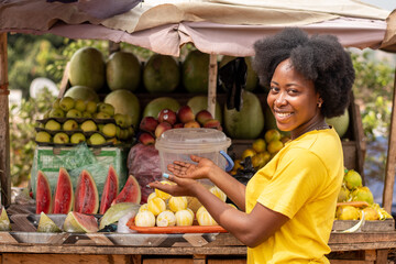 portrait of young african woman selling fruits