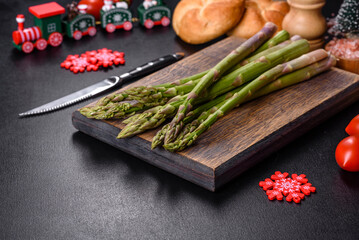 Delicious fresh raw green asparagus stalks on wooden cutting board