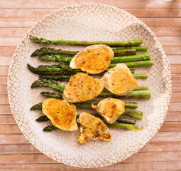 cooked dish. Chicken nuggets with green asparagus on plate