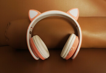 Pink and white headphones on colored background. Music concept.            