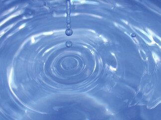 Water drop falling into water making a perfect droplet splash