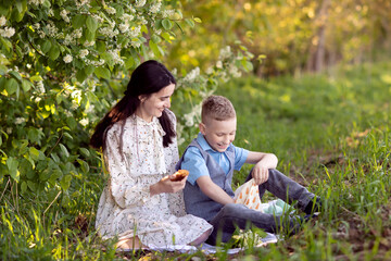 Cute baby eats picnic food with mom