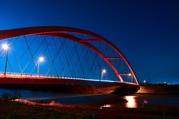 Fototapeta na wymiar 夜の闇に浮かぶ赤い橋と光るライト