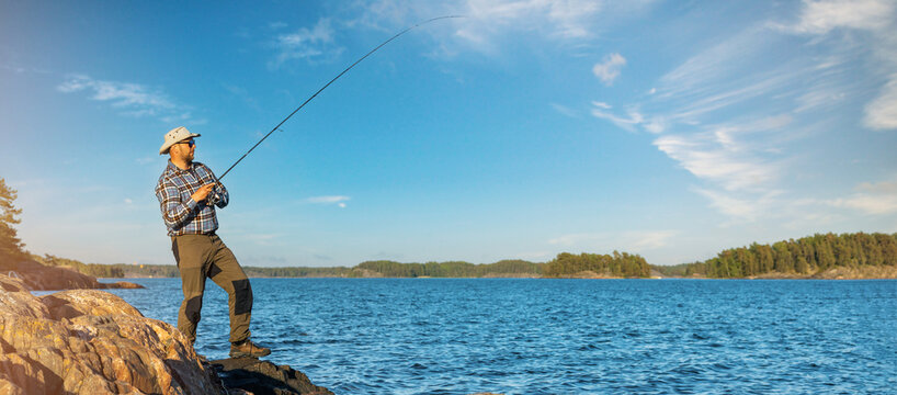 fisherman fishing from the coast in Finland sea archipelago. copy space