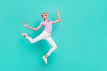 Full length body size view of attractive cheerful flexible sportive girl jumping dancing isolated over teal turquoise color background © deagreez