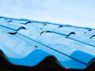 Old blue tiled roof contrasts with the sky.  - 511065316