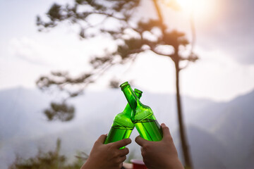 camping concept, Cheers glass bottle by camping people together at their camping site at the mountain