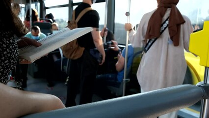 Female passenger reading a book in the bus - Powered by Adobe