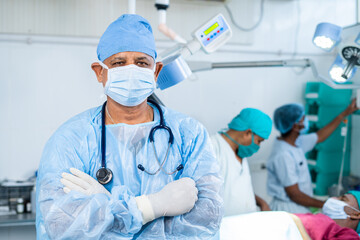 Portriat shot of Confident surgeon at operation theater standing confidently with crossed arms by looking camera - concept of healthcare, professional occupation and medicare.