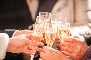 a glass of champagne in the hand of the bride and relatives at the party. Wedding party with champagne. selective focus. People hold glasses of champagne in hands at a holiday wedding party. blurry