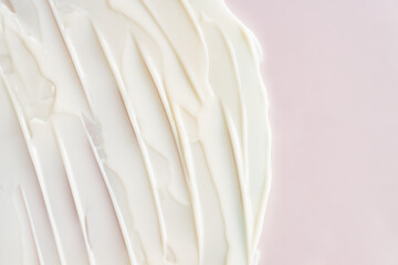 Cosmetic cream milk texture on pink colored background. Copy space