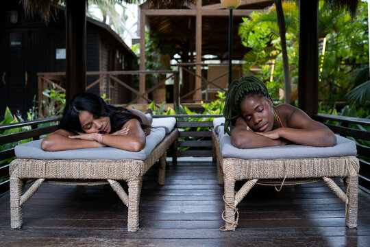 Black women lying on lounges during spa session