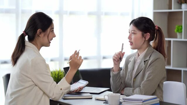 Two beautiful young asian businesswoman working together in office, executive consulting Asian woman client.