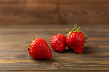 Fresh ripe strawberry on brown texture background.Vegetarian organic berry.Healthy food.Copy space.Place for text