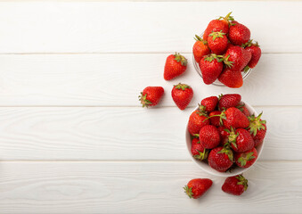 Fresh ripe strawberries in a plate on a white wooden background.Vegetarian organic berry.Healthy food.Vitamins.Copy space.Space for text