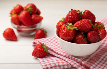Fresh ripe strawberries in a plate on a white wooden background.Vegetarian organic berry.Healthy food.Vitamins.Copy space.Space for text
