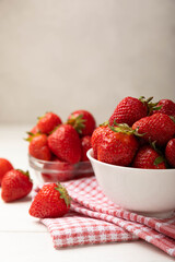 Fresh ripe strawberries in a plate on a white wooden background.Vegetarian organic berry.Healthy food.Vitamins.Copy space.Space for text